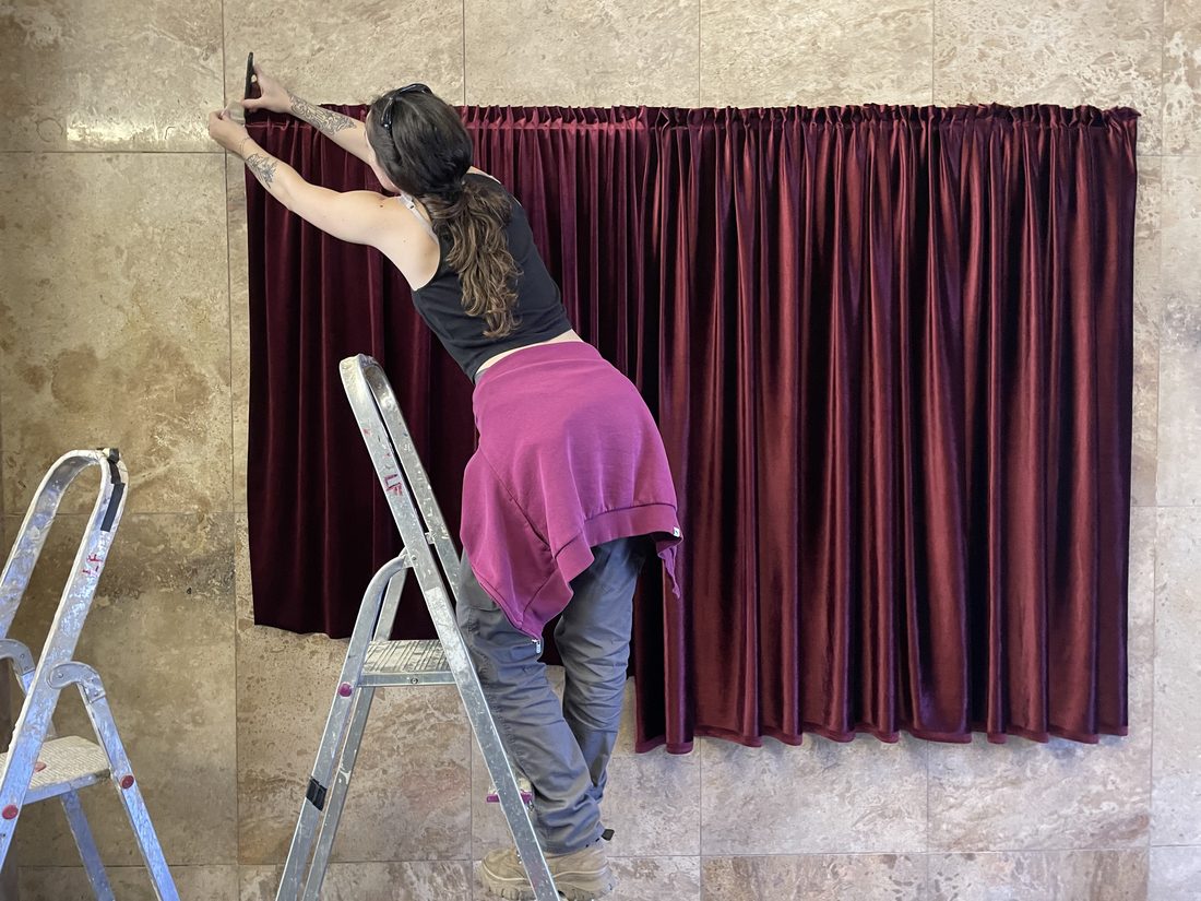 Irene dressing velvet curtains on set