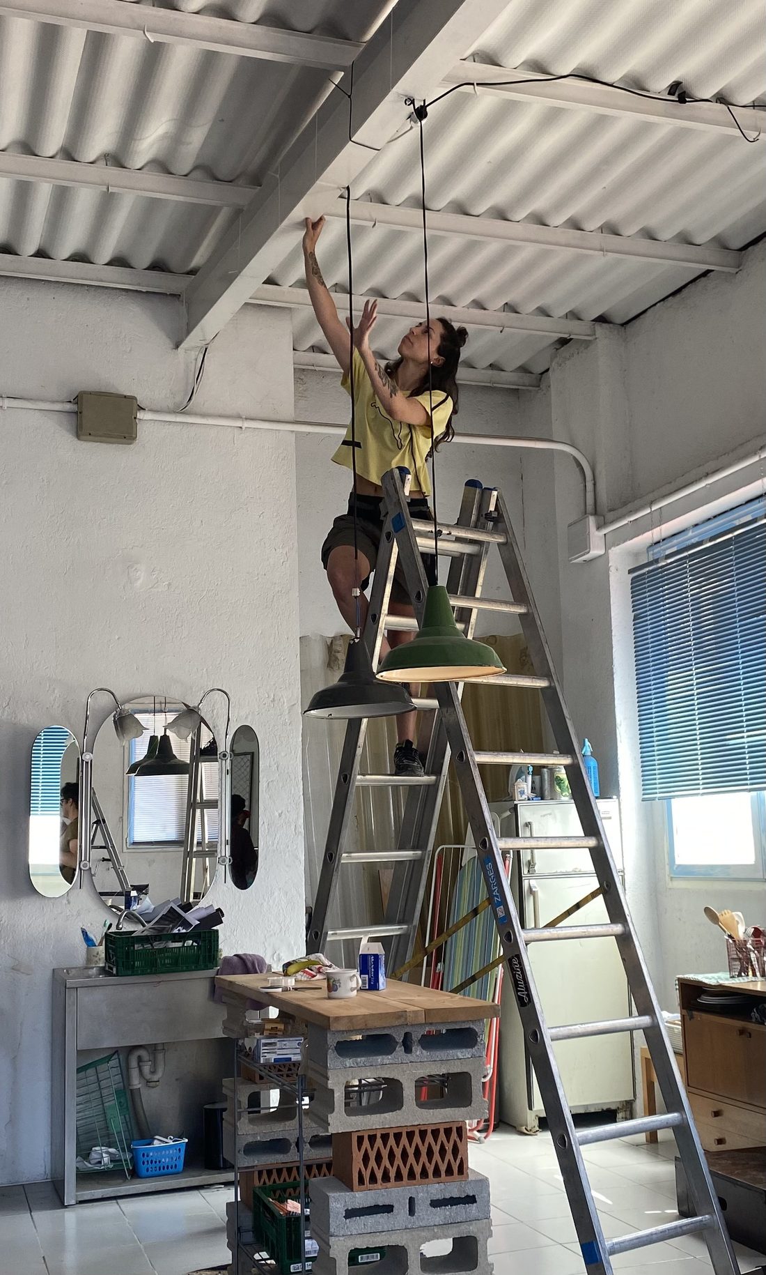 Irene installing lighting fixtures on set